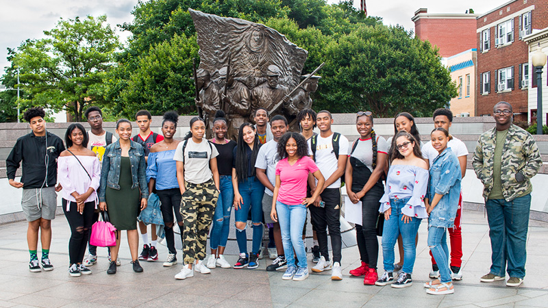 Students on a field trip in front of a statue