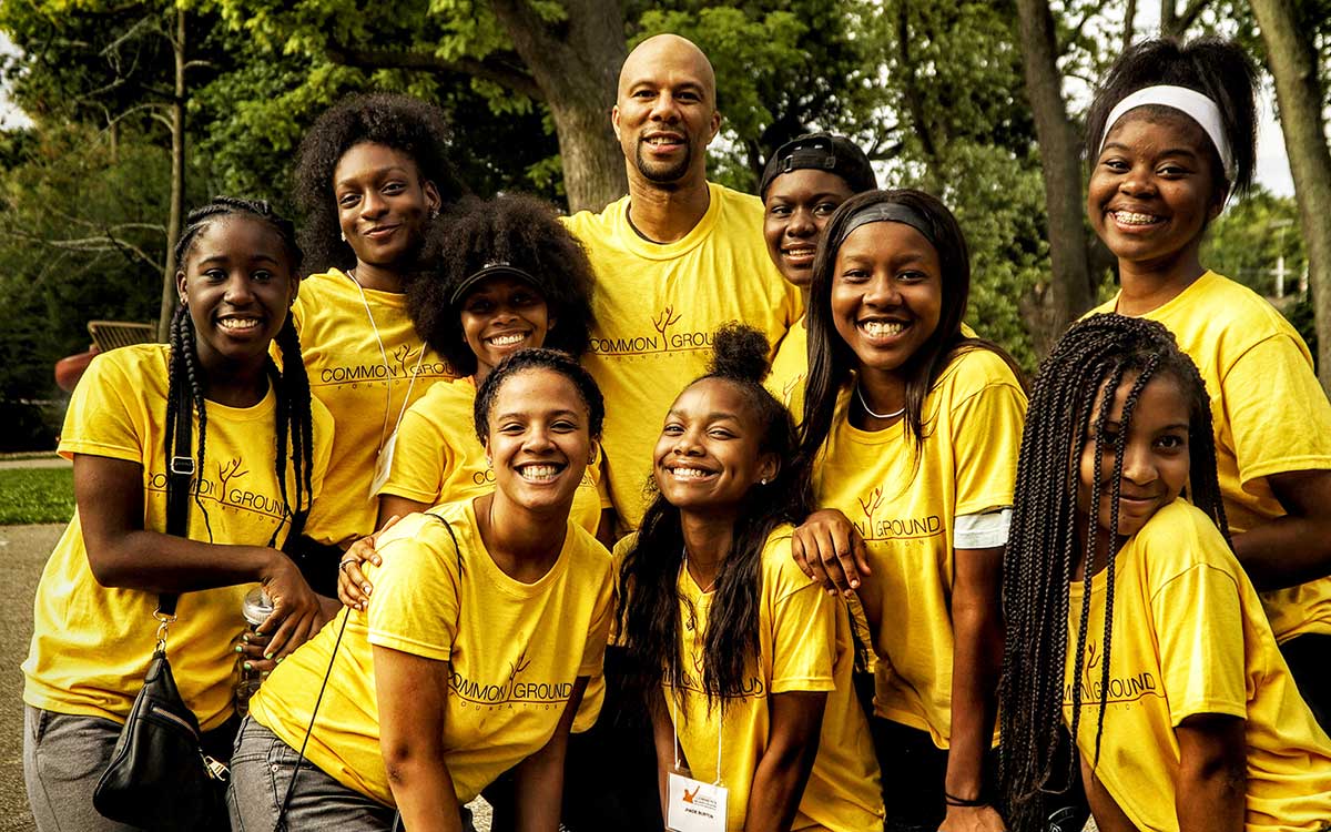 Common posing with a group of students in their yellow shirts